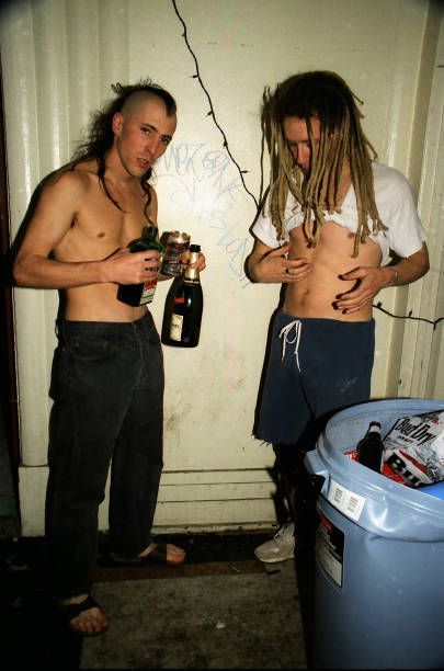 two men standing next to each other holding bottles