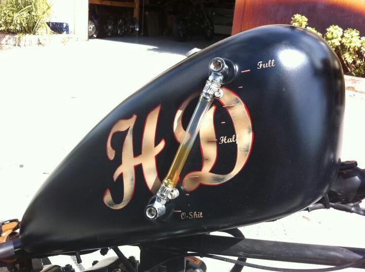 the side view of a black motorcycle with gold letters on it's fenders