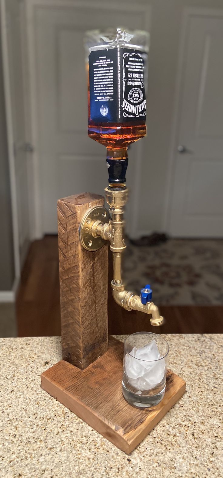 an old fashioned faucet turned into a whiskey dispenser with ice in it