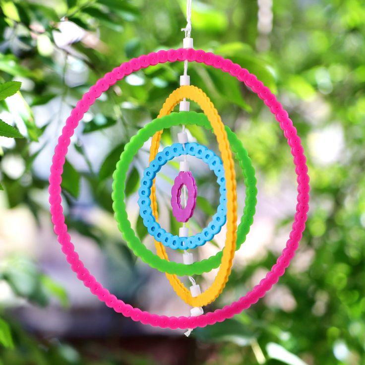 an ornament hanging from a tree in the sun with beads and rings around it