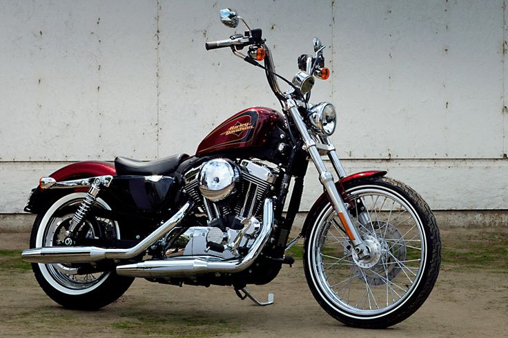 a red and black motorcycle parked in front of a building