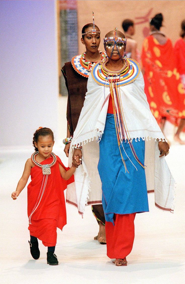 a woman and child walking down a runway