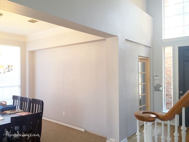 an empty living room and dining area with stairs leading up to the second story door