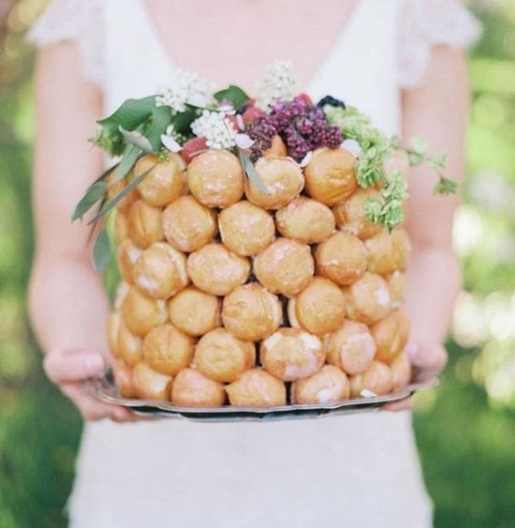 a woman holding a plate full of donuts