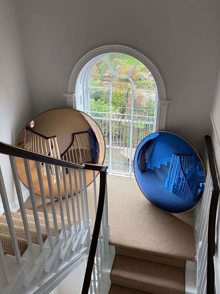 the stairs are made of wood and have round blue seats on them, along with an arched window