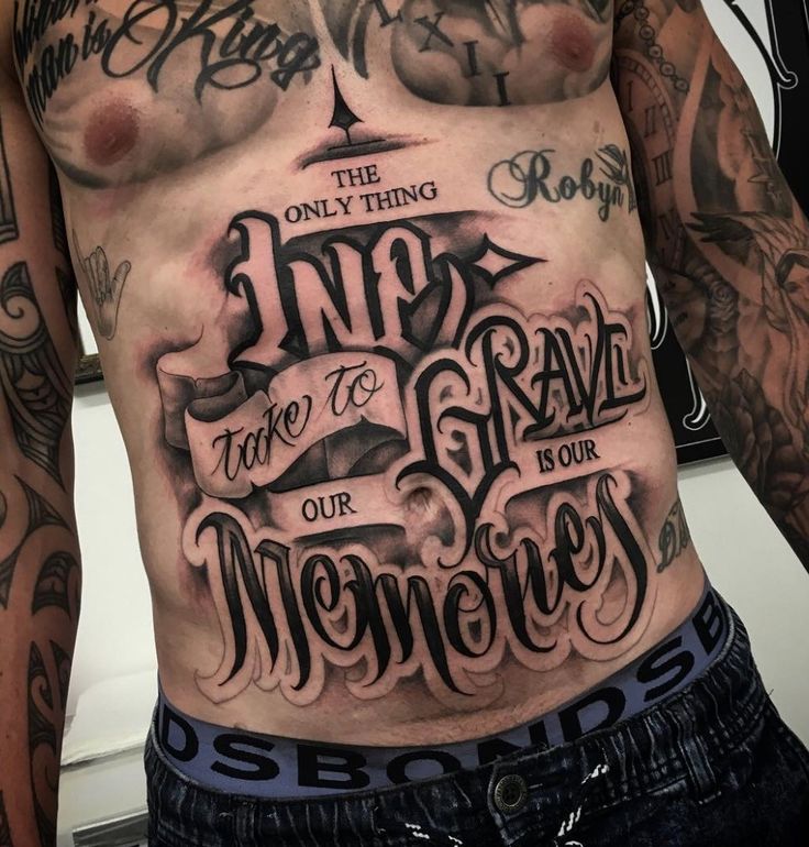 a man's chest with tattoos and lettering on it