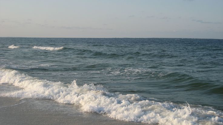 the ocean waves are rolling in to shore