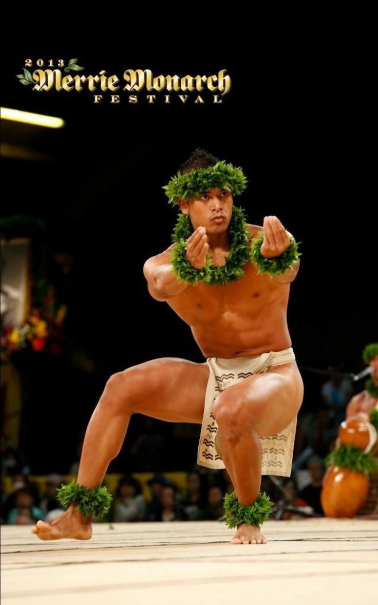 a sumo wrestler is performing in front of an audience with his hands on his hips