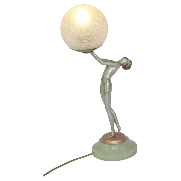 a lamp with a person holding a ball on it's arm and standing up