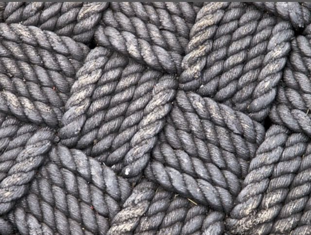 gray rope is piled together in this close up photo, as if it were used to make a background