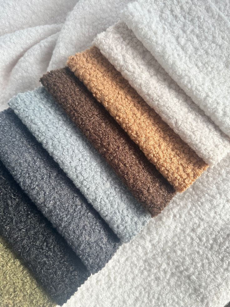 towels folded on top of each other in different colors and sizes, all lined up side by side