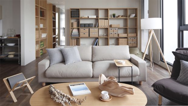 a living room filled with furniture and lots of bookshelves on the wall next to a window