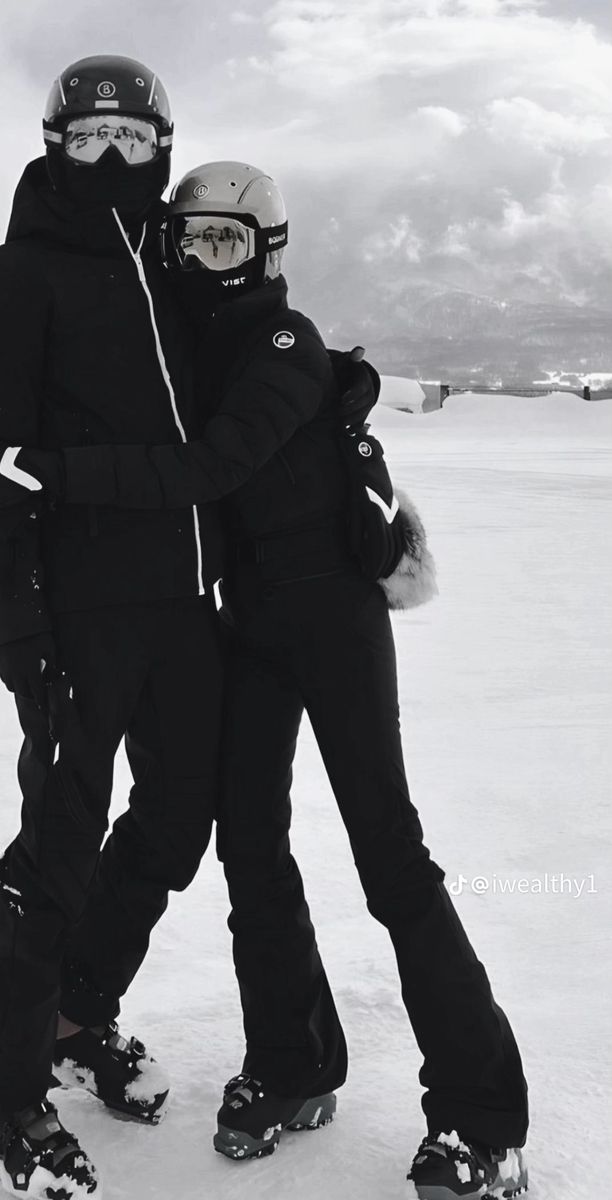 two snowboarders hugging each other in the snow