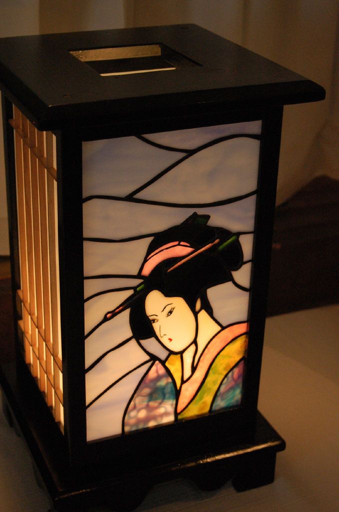 a stained glass lantern with a woman holding a fan