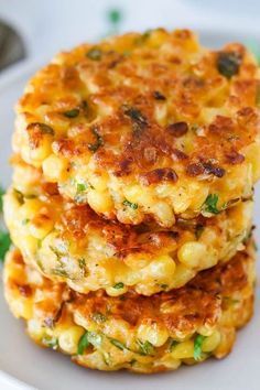 two crab cakes stacked on top of each other in a white plate with green garnishes