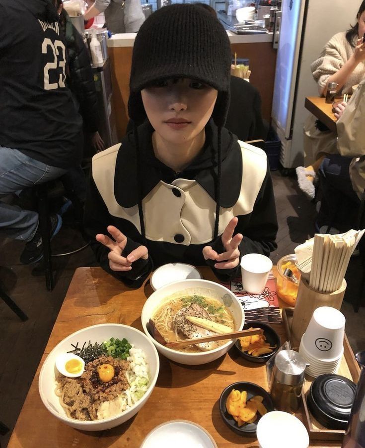 a person sitting at a table with bowls of food