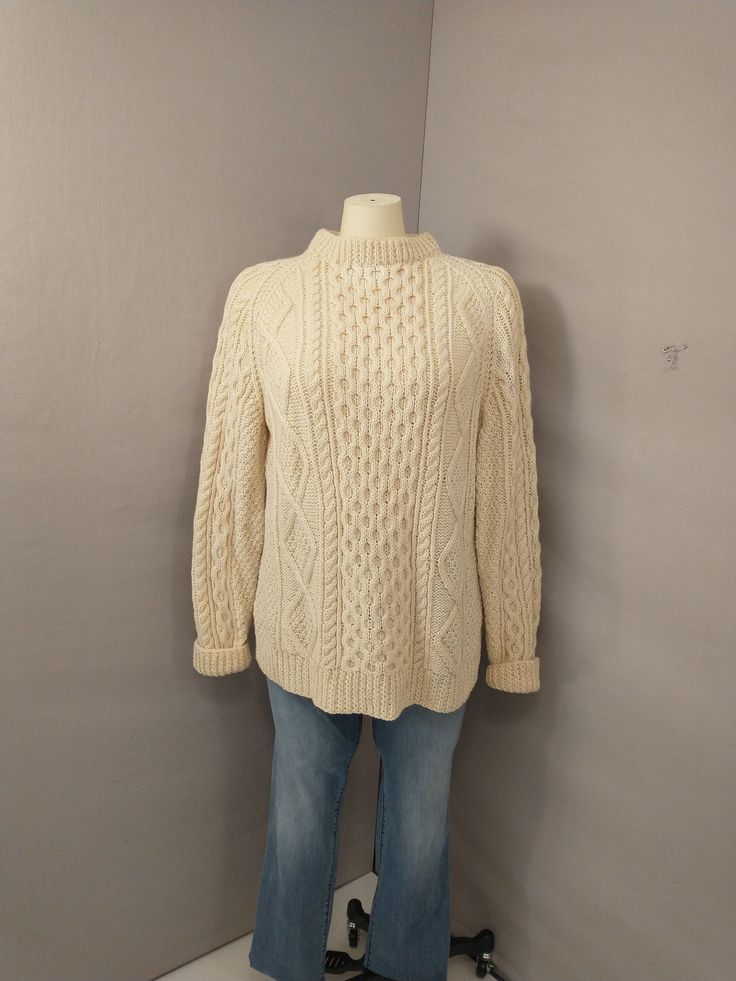 a mannequin wearing a white sweater and jeans