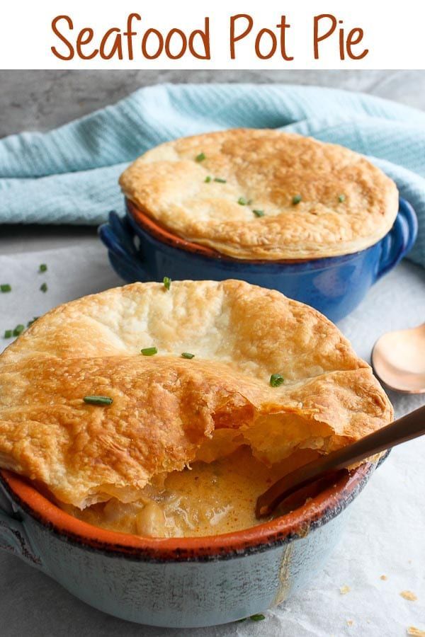 two pot pies sitting on top of a table next to a blue dish with a spoon in it