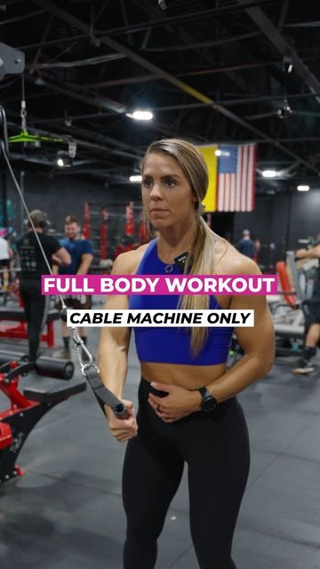 a woman in a blue top and black leggings is holding a cable machine