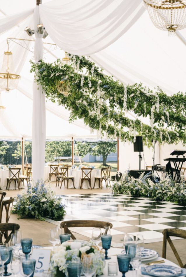 an outdoor tent with tables and chairs set up for a formal function or wedding reception