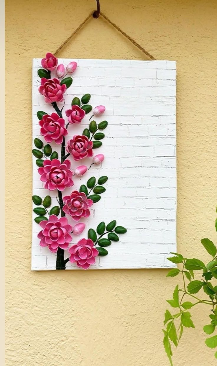 paper flowers are hanging on the wall next to a potted plant