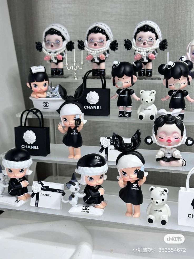 a display case filled with lots of little dolls and purses in black and white outfits