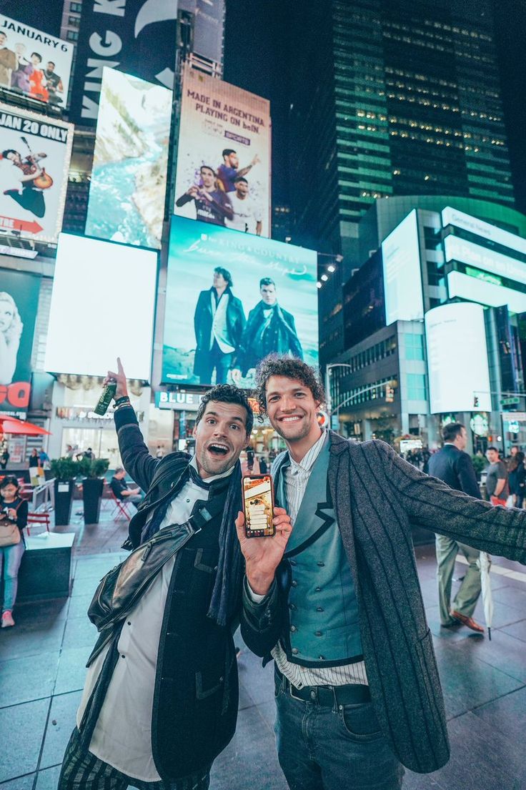 two men standing in the middle of times square