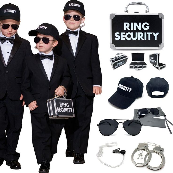 two young boys dressed in black suits and sunglasses, one holding the hand of another boy