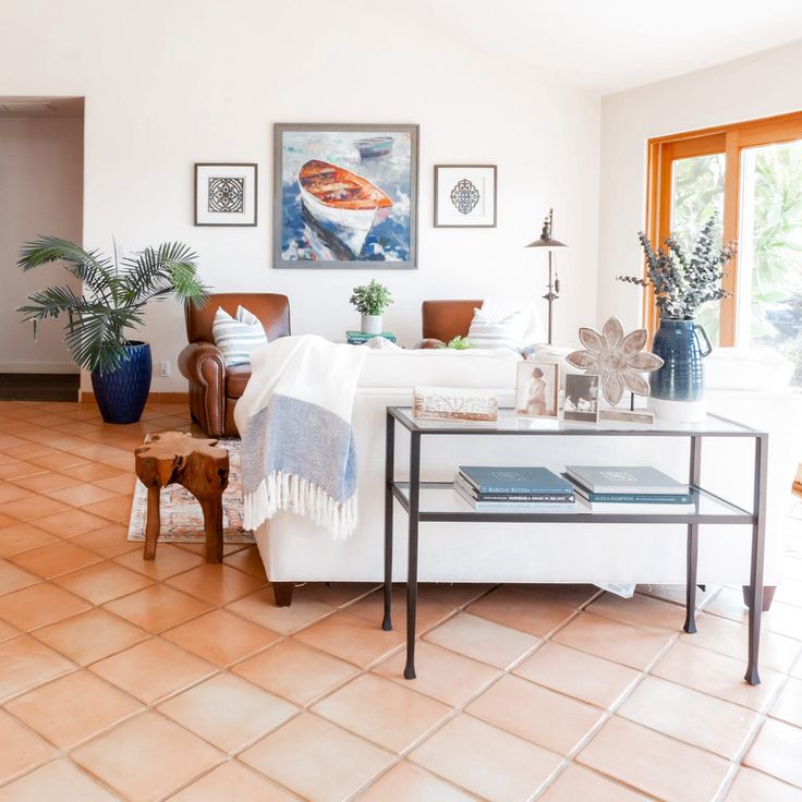 a living room filled with furniture and potted plants