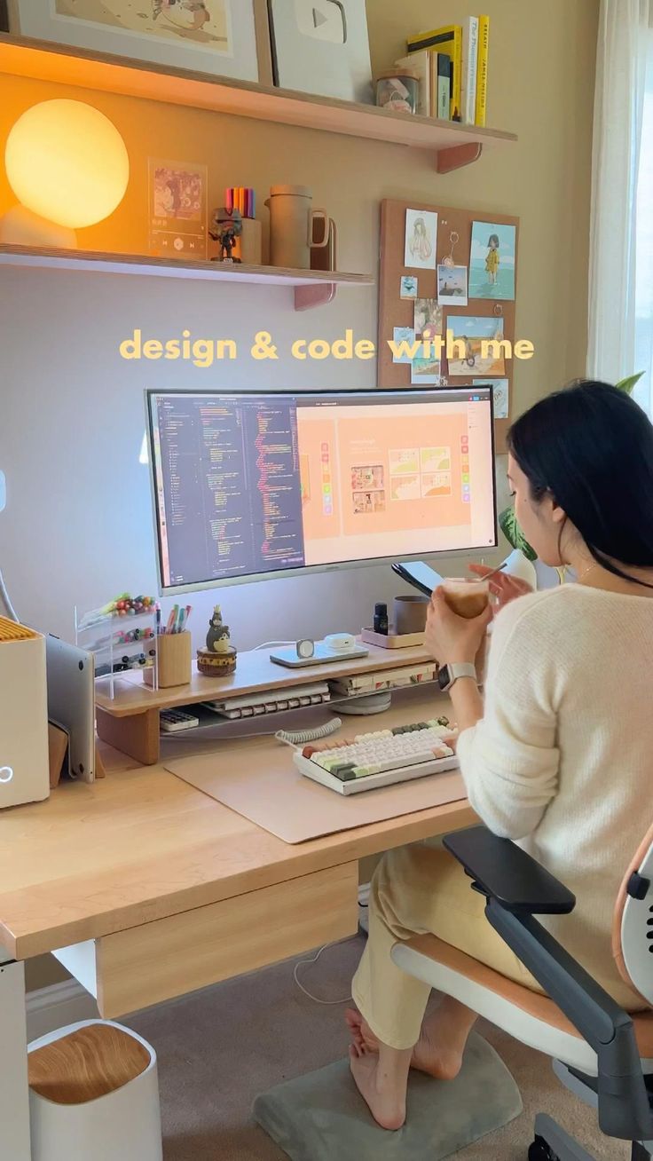 a woman sitting in front of a computer desk