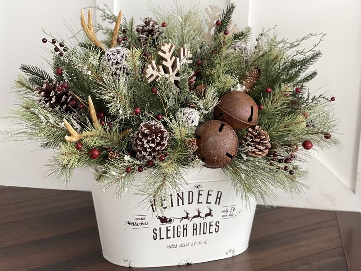 a white bucket filled with pine cones and christmas decorations