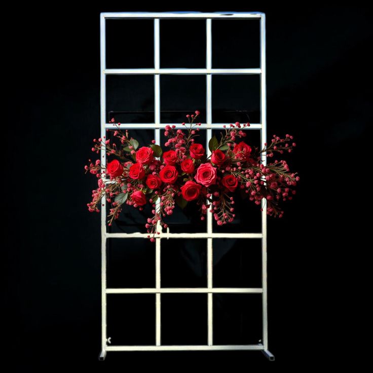 red flowers are arranged in a white trellis on a black background with space for text