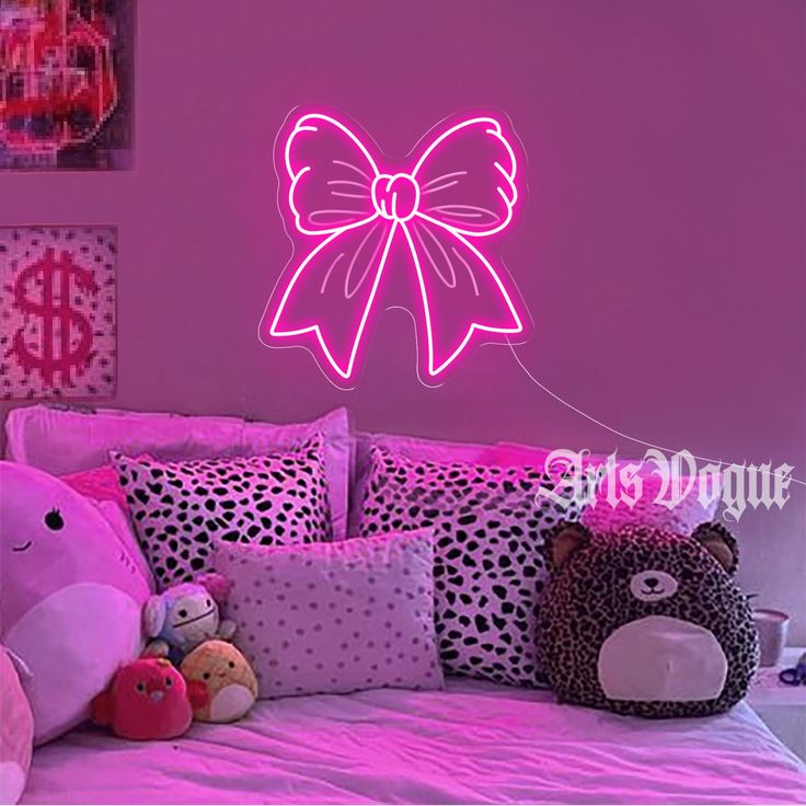 a bedroom with pink walls and stuffed animals on the bed in front of the wall