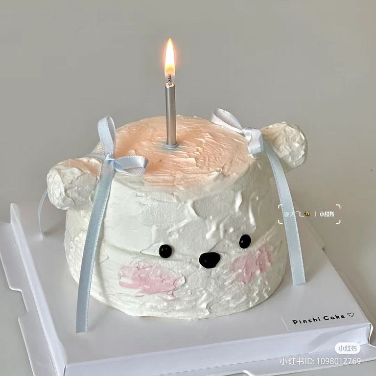 a birthday cake with a candle in the shape of a bear