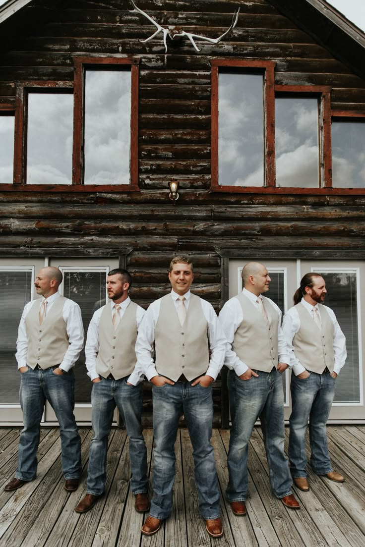 a group of men standing next to each other in front of a wooden building with windows