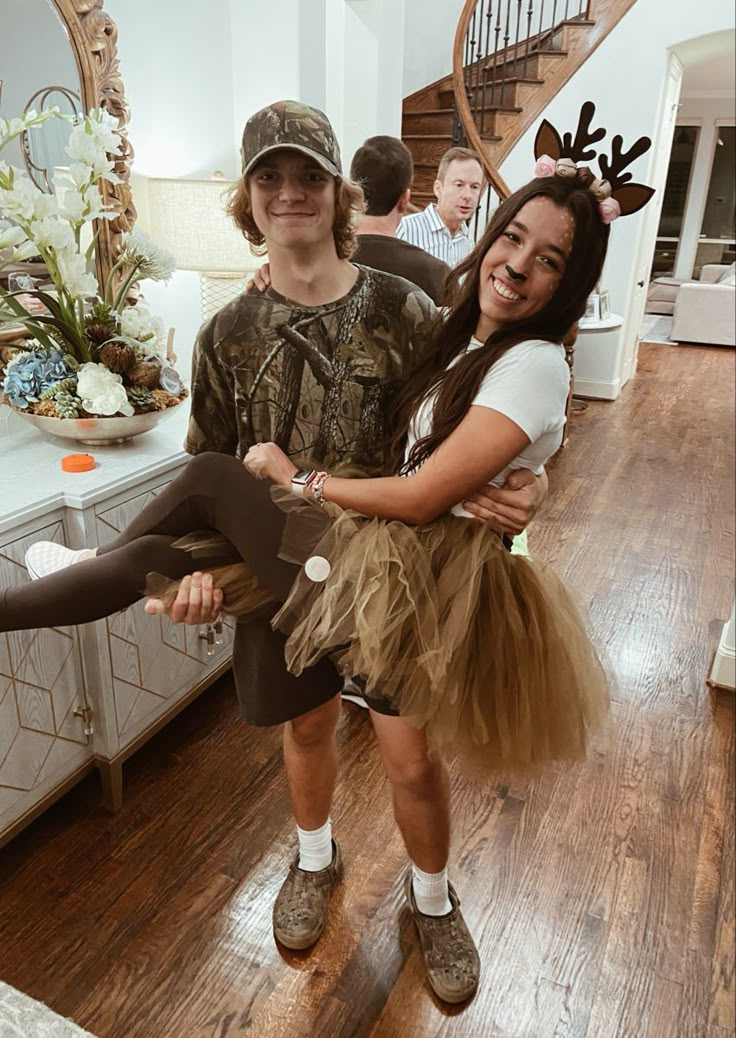 a young man and woman are dressed up as deer antlers in the living room