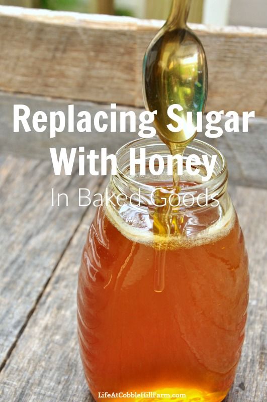 a glass jar filled with honey sitting on top of a wooden table