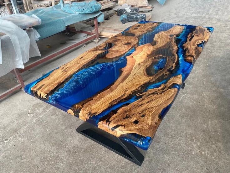 a table that is made out of wood and blue glass in the middle of it