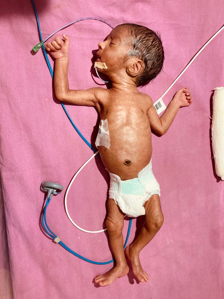 a baby in diapers holding a hair dryer and plugged into the wall