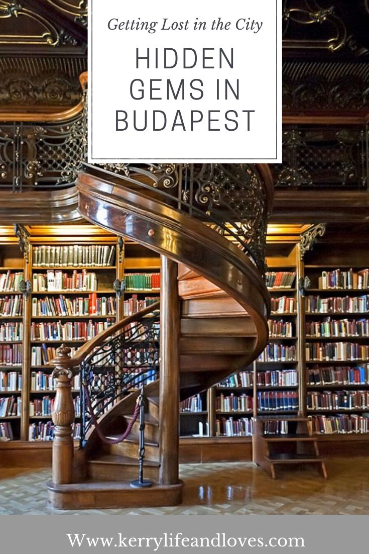 a spiral staircase in front of a bookshelf with the words getting lost in the city hidden gems in budapest