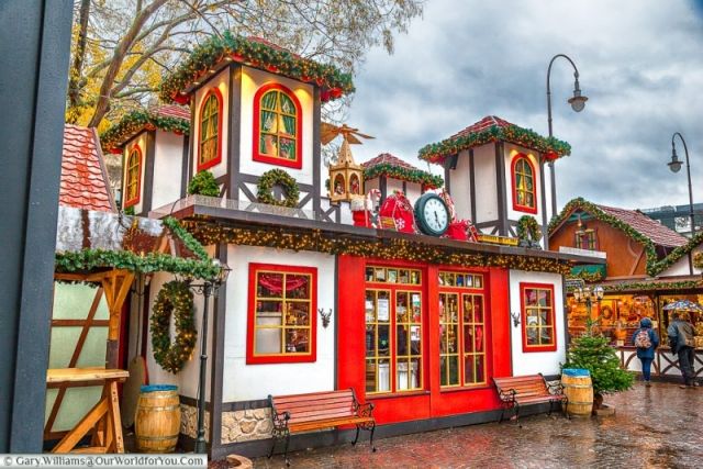 a red and white building with christmas decorations on it's roof in the rain