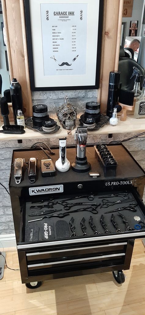 a table with many different items on it in front of a framed poster and hair dryer