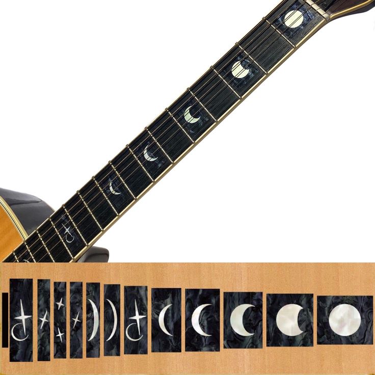 an electric guitar sitting on top of a wooden shelf next to the moon phase chart