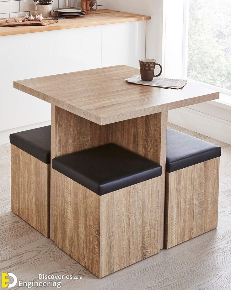 a kitchen table with two stools and a coffee cup on it in front of a window