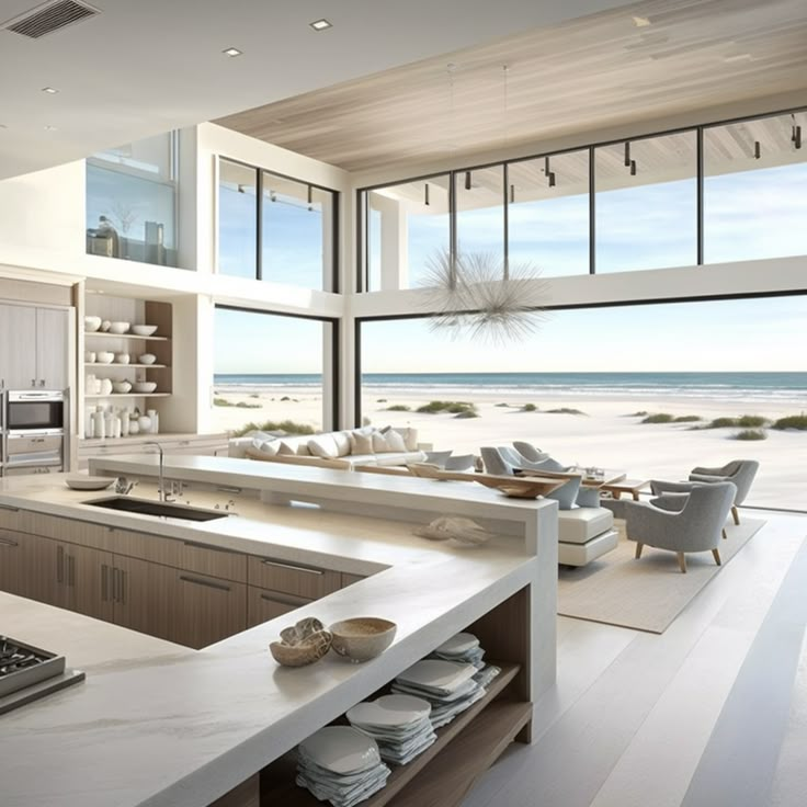 an open kitchen and living room area with large windows looking out to the beach in front of it