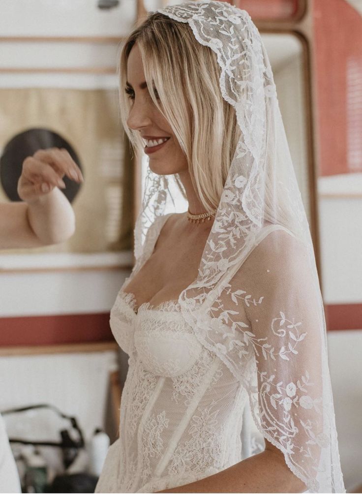 a woman in a wedding dress getting ready to go into her bridal gown and veil