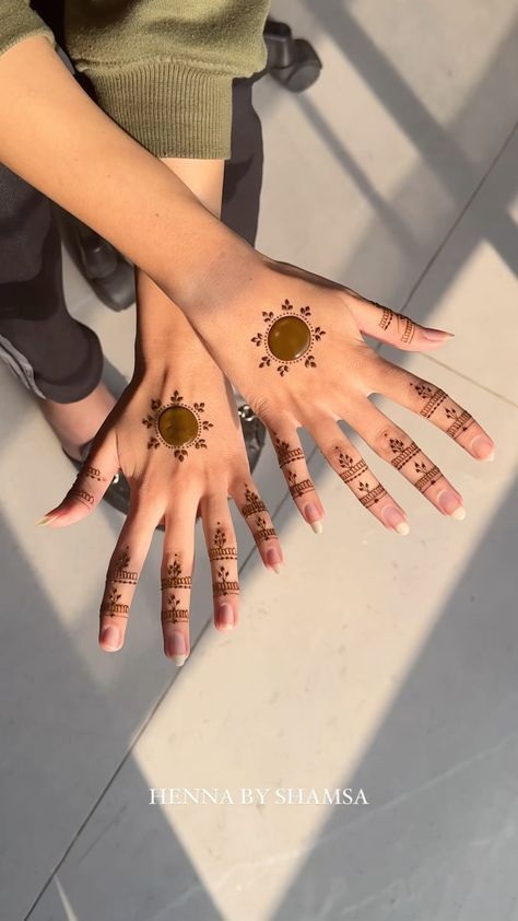 two hands with henna designs on them