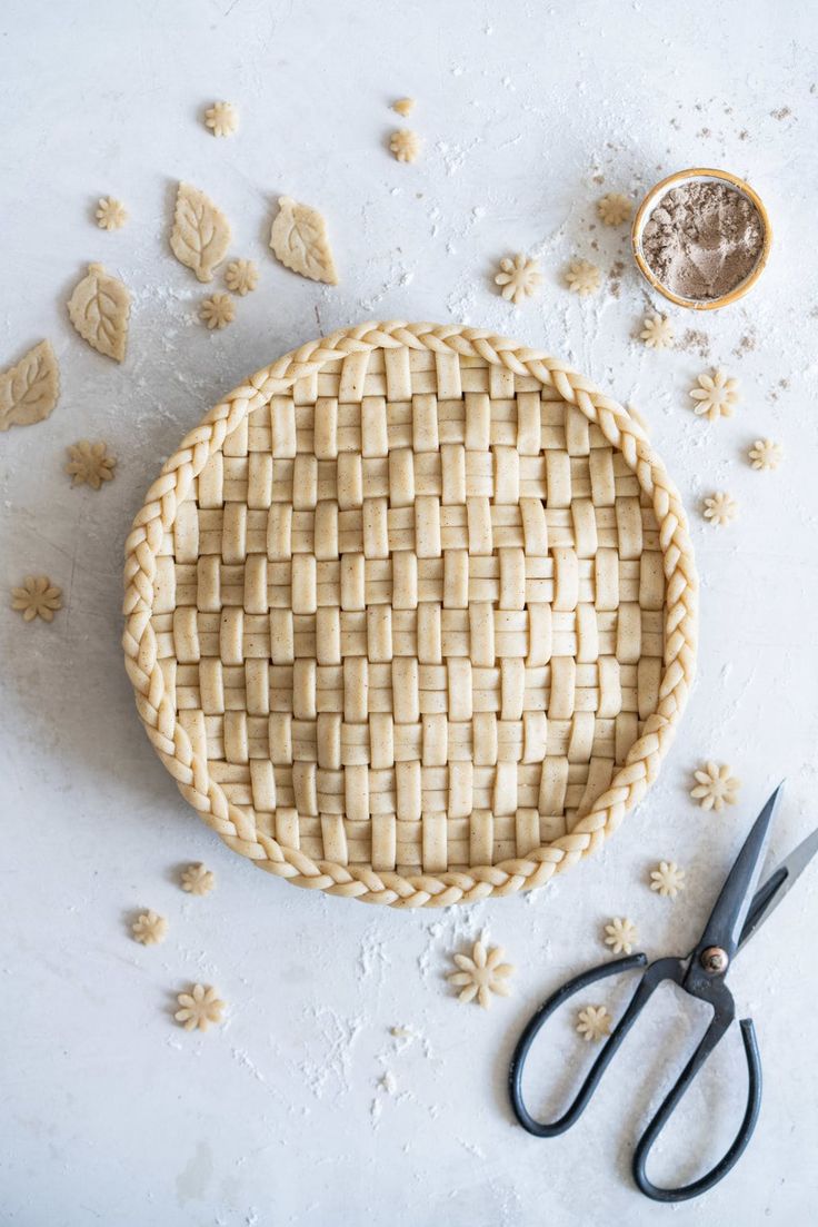 a pie crust sitting on top of a table next to some scissors and other items