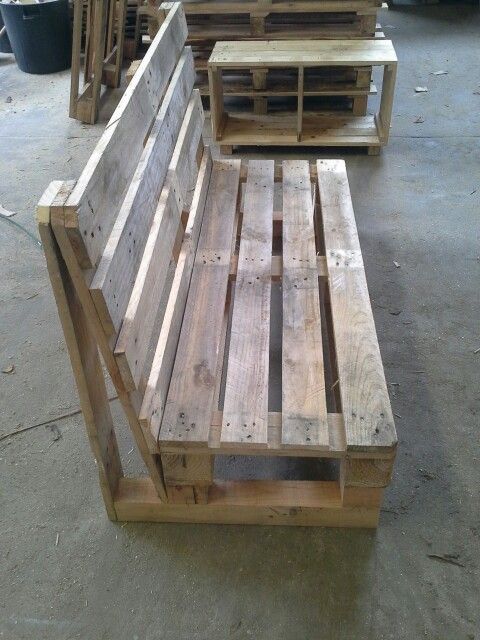 a wooden bench made out of pallets in a warehouse