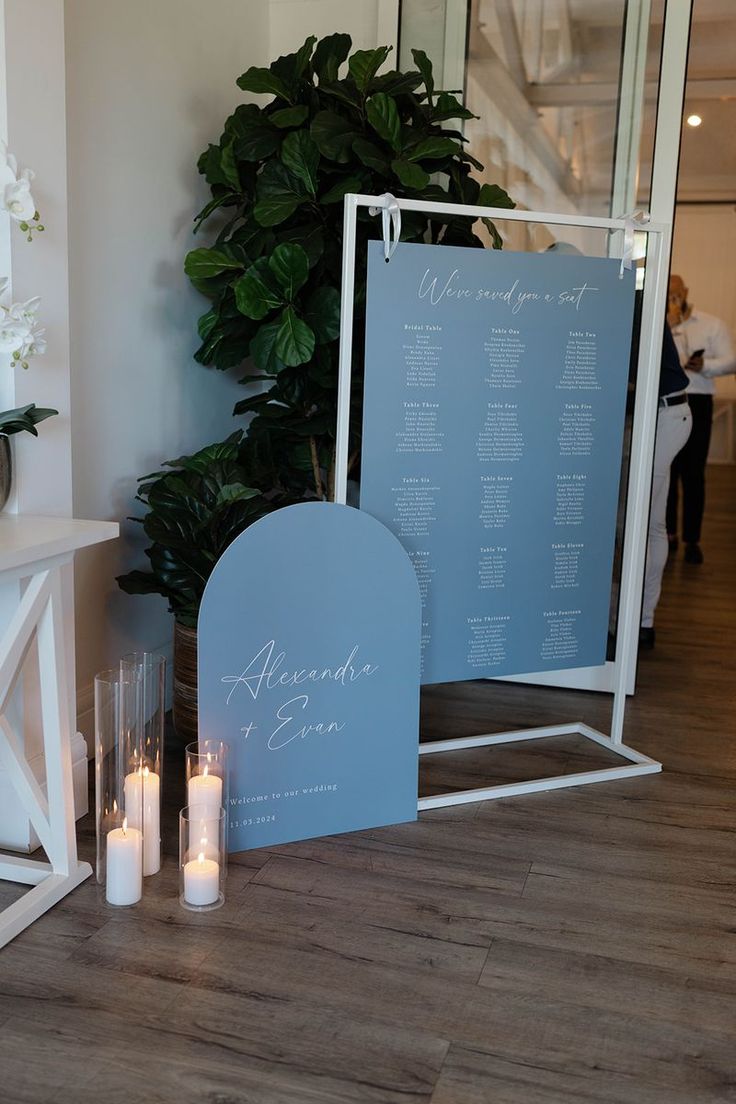 a couple of signs sitting on top of a wooden floor next to candles and flowers